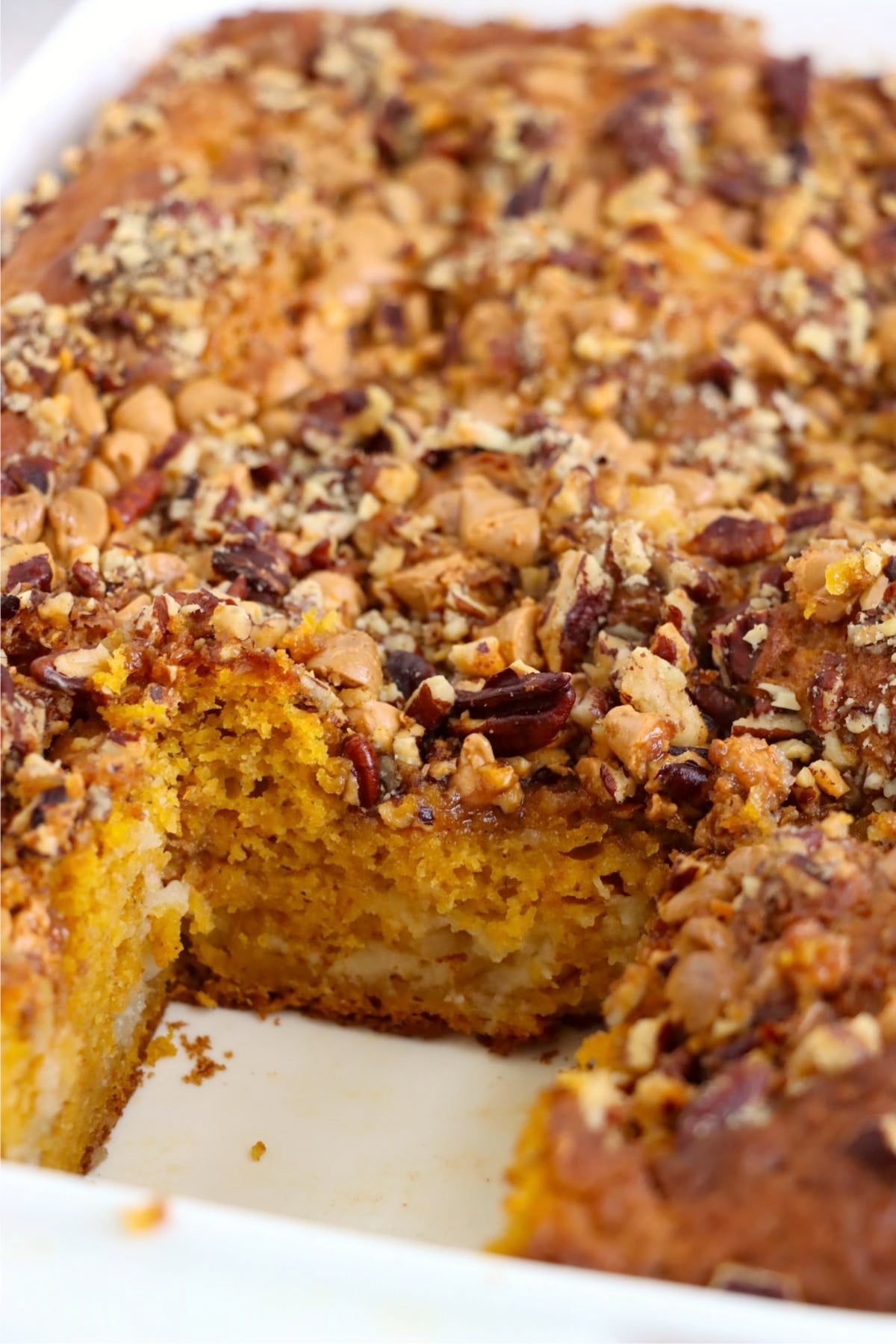 Piece taken out of a pumpkin earthquake cake in a baking dish.