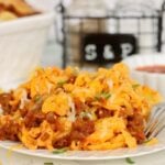 Cheesy ground beef and egg noodles with melted cheese and fresh green garnish.